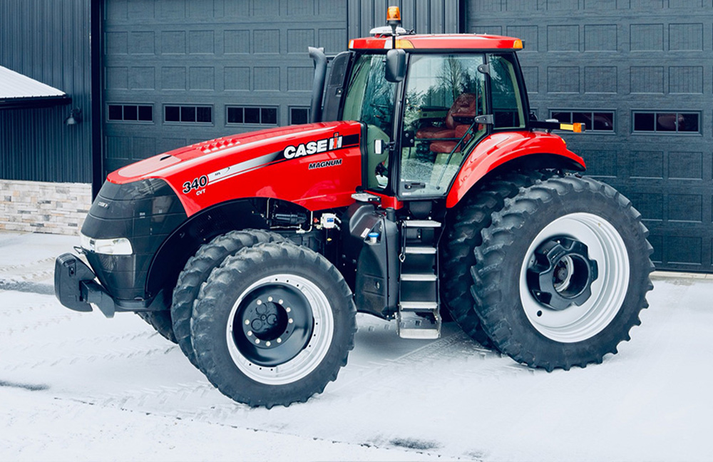 a Case IH Tractor in the snow infront of barn