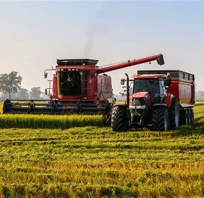 A combine filling a grain cart within a field