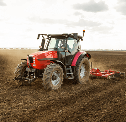Rred tractor using tillage equipment on a field