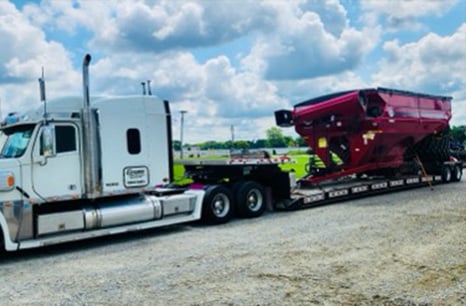 White Sleeper truck carryinf a red grain cart