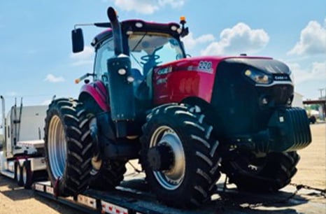 Case IH 220 tractor being carried on a flat bed trailer 